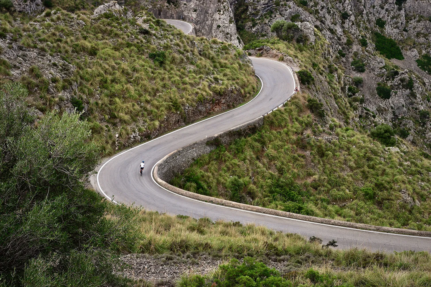 A road cyclist riding through the scenic mountains from Madrid to Segovia.