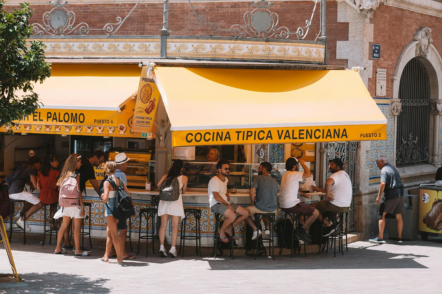 People enjoying tapas and beer at the Valencia Central Market.