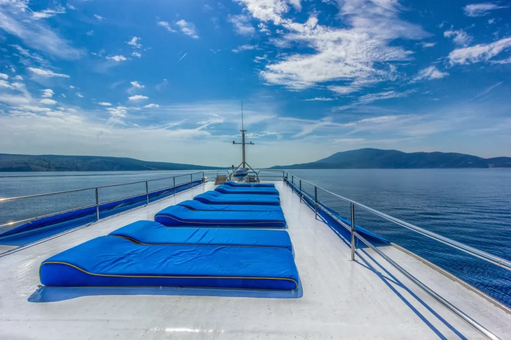 Sunbathing deck of the MS Linda boat with blue sun loungers facing the sea in Croatia.