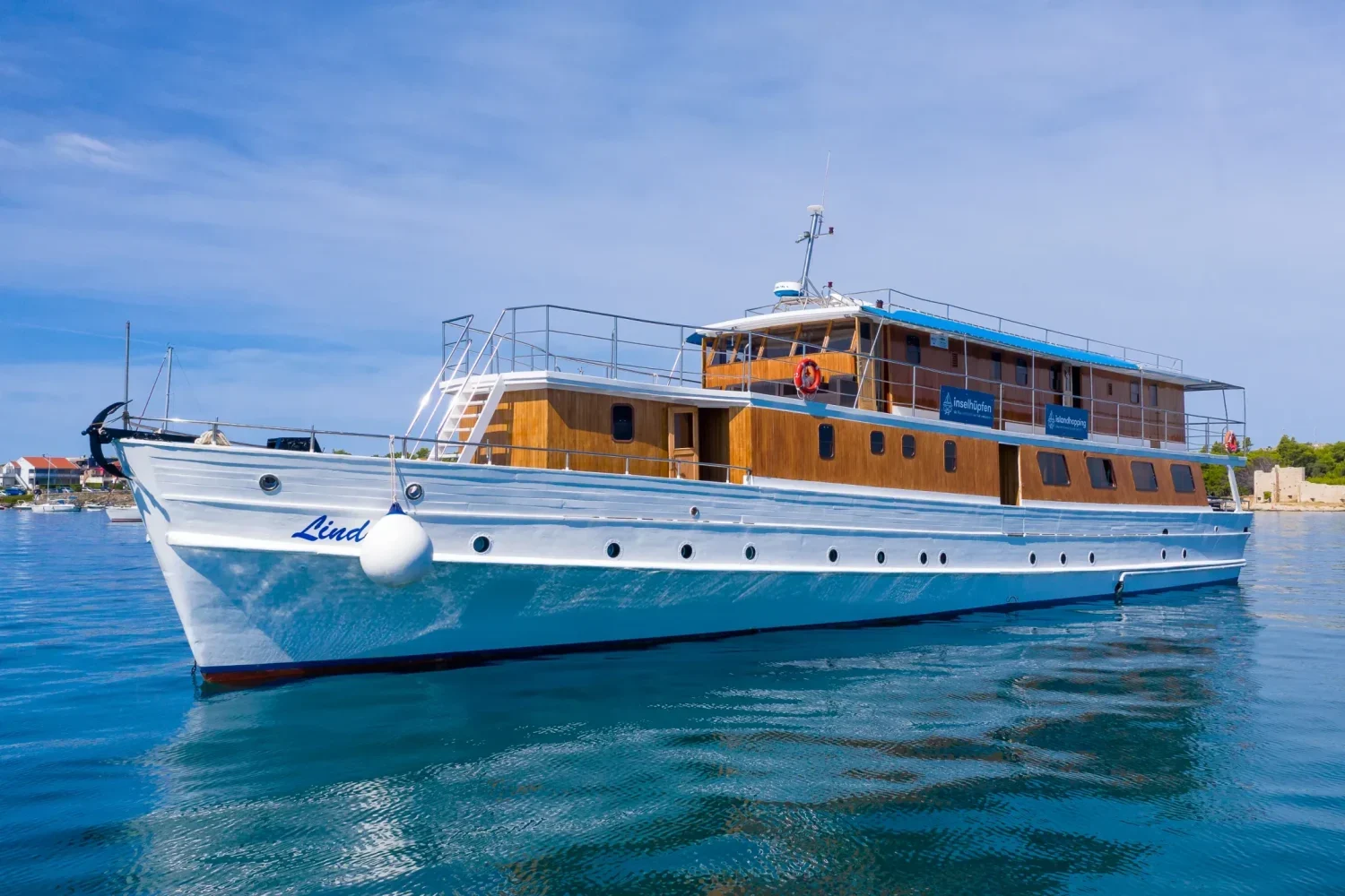 Side profile view of the white and wooden MS Linda motor yacht anchored at sea in Croatia